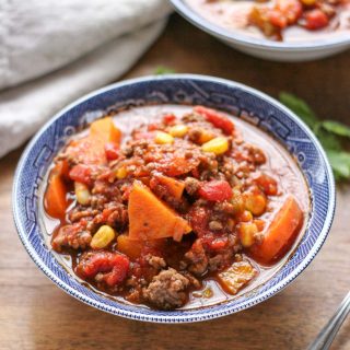 Two blue bowls filled with Easy Weeknight Hamburger Soup with Sweet Potatoes on a brown wood table