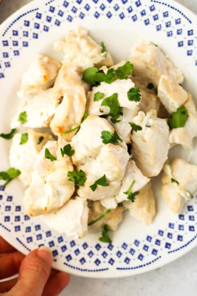 Tzatziki Chicken Breasts bites on a white plate.