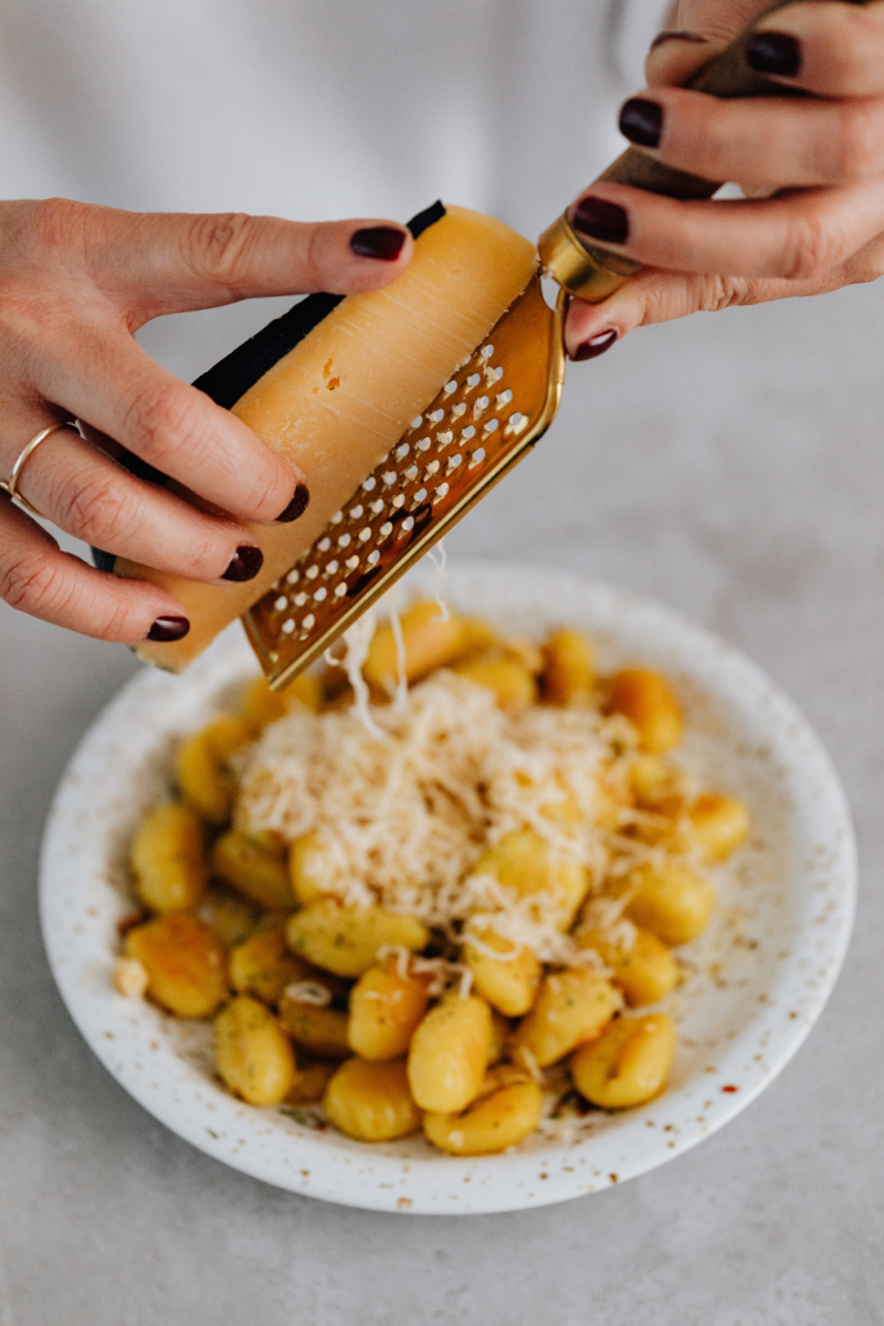 grating cheese on gnocchi.