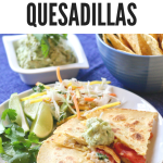 Simple Haddock Quesadillas on a white plate with lime wedges and cilantro on the side