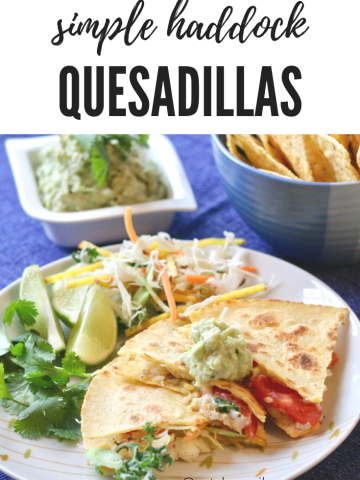 Simple Haddock Quesadillas on a white plate with lime wedges and cilantro on the side